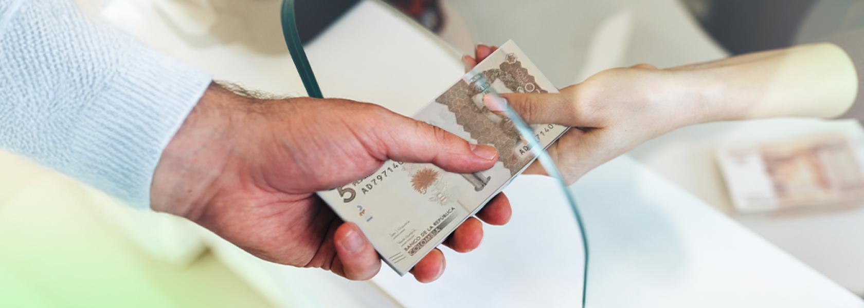 Manos con billetes en ventanilla