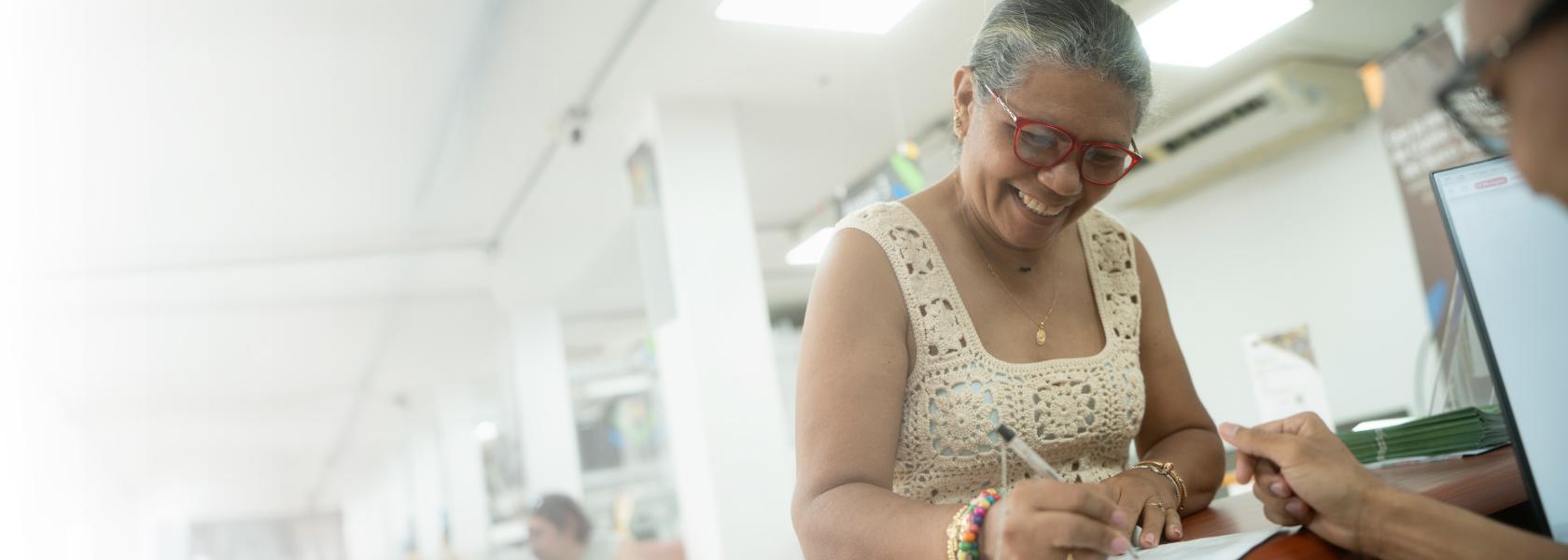 mujer firma documento y sonríe