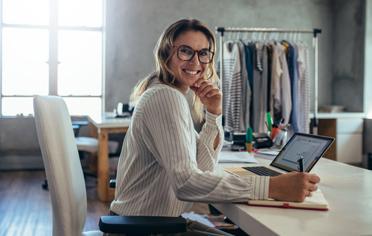 mujer en oficina con computador sonriendo
