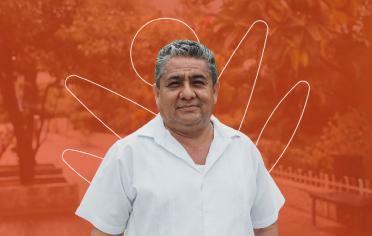 Señor con camisa blanca sonriendo con un fondo rojo