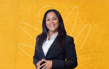 Mujer empresaria sonriendo con un fondo amarillo